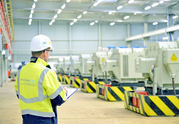 Fachkraft mit Helm inspiziert Hauptpumpenstation